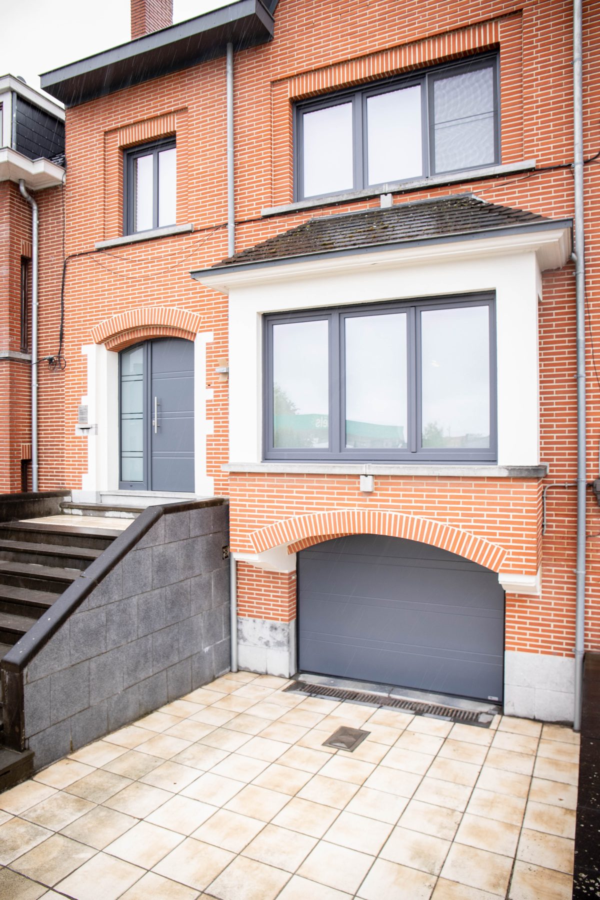 Sektionaltor in Anthrazit an einer Klinkerfassade mit Rundbogen